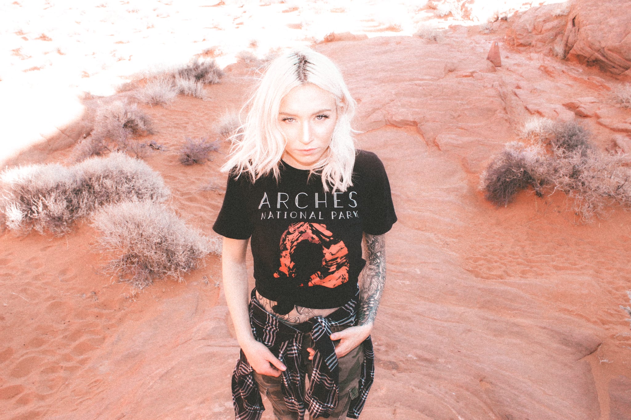 one female in a valley with an Arches National Park shirt