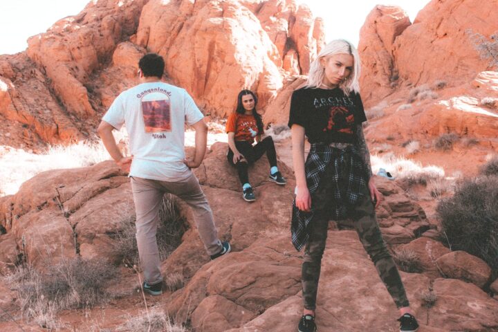two women and one male in a valley of red rocks